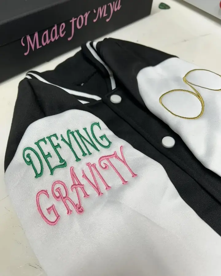 Black and cream letterman jacket with decorative sleeve embroidery